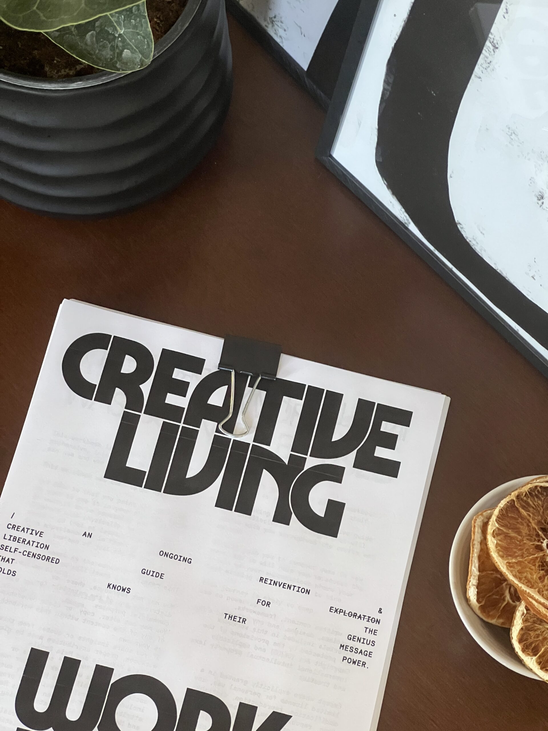 An image of a stack of papers clipped together with the words "Creative Living" in bold, chunky font.